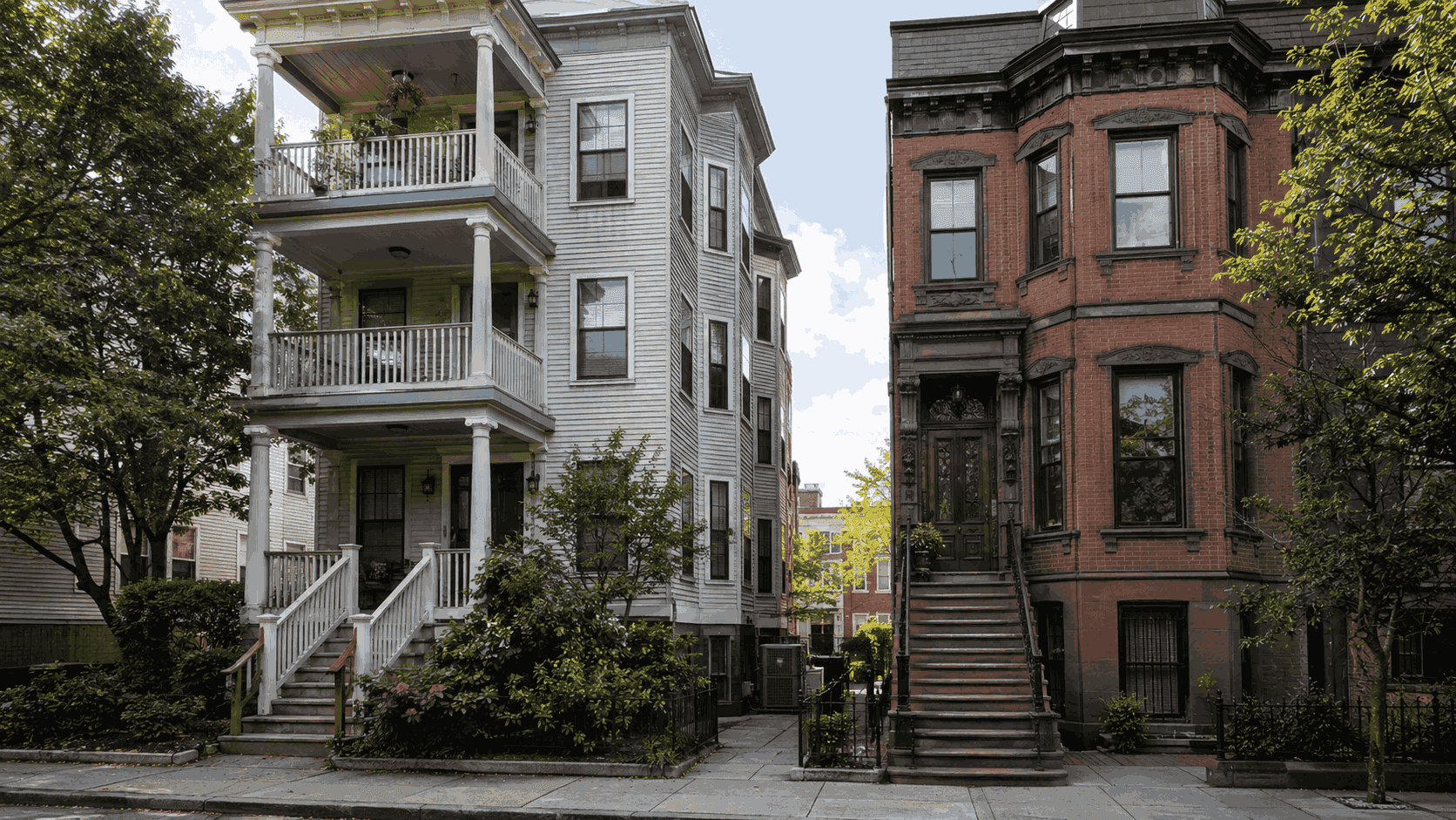 Boston triple-decker and brownstone rowhouse side by side showing the two historic housing types requiring different HVAC retrofit approaches